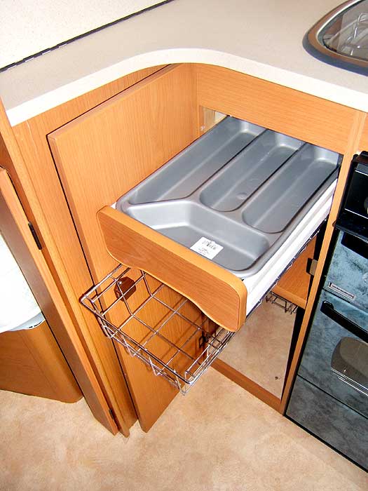 This cupboard beneath the worktop has a cutlery drawer and storage basket.